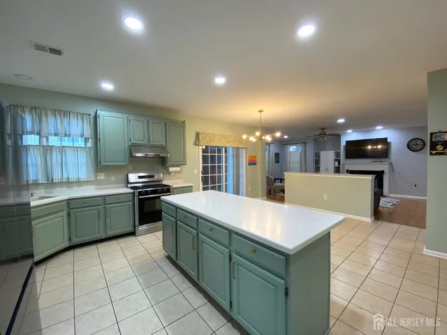 a large kitchen with kitchen island a sink a counter top and stainless steel appliances