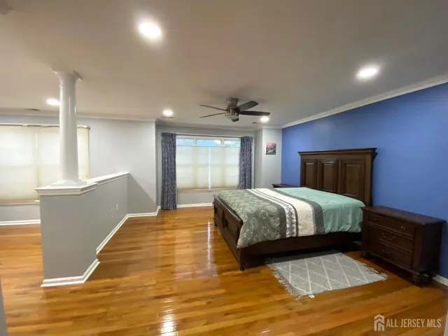 a spacious bedroom with a bed and a dresser next to a window
