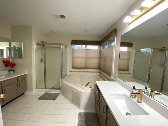 a bathroom with a tub sink and mirror