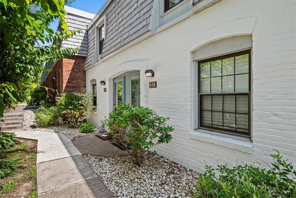 a front view of a house with a yard and potted plants
