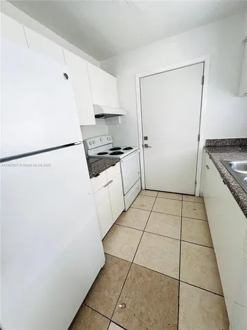 a kitchen with a stove a refrigerator and a stove top oven