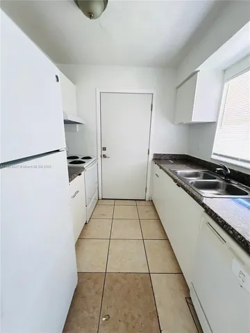 a kitchen with white cabinets and white appliances