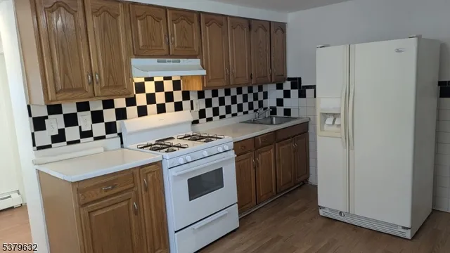 a kitchen with a stove a sink and a refrigerator