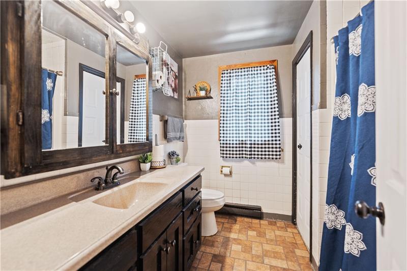 5158 McCandless Road Butler, PA 16001 - Photo 29 of 41 a bathroom with a double vanity sink a toilet and a mirror