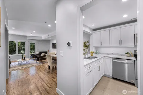 a kitchen with white cabinets and sink