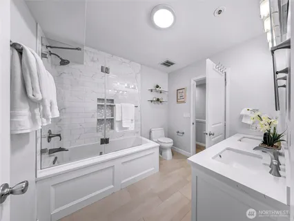 a bathroom with a bathtub shower sink and toilet