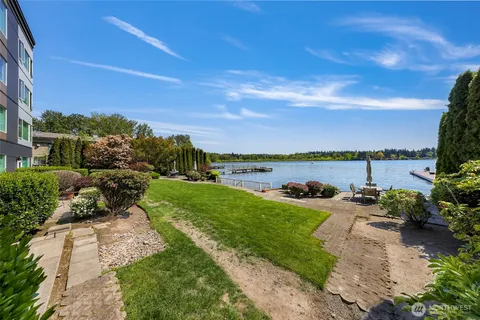 a view of a lake with lawn chairs and a yard