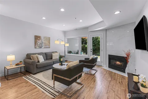 a living room with furniture a flat screen tv and a fireplace