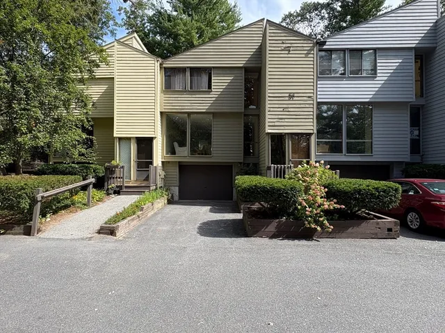 a front view of a house with a yard and potted plants