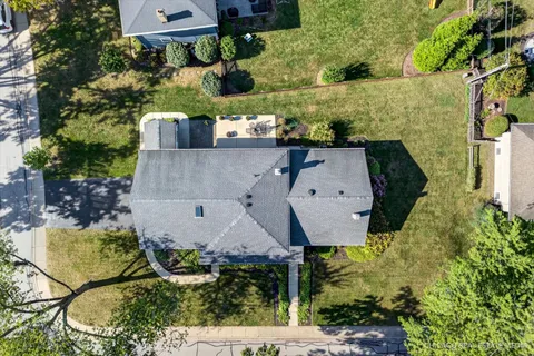 an aerial view of residential houses with outdoor space and trees