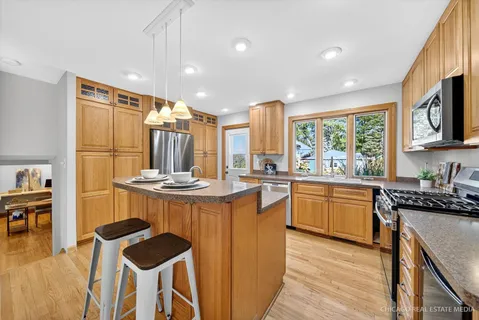 a kitchen with kitchen island granite countertop wooden floors and stainless steel appliances