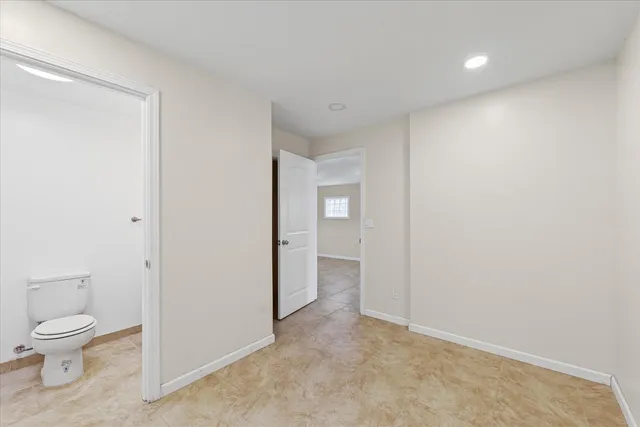 a bathroom with a toilet sink vanity and mirror