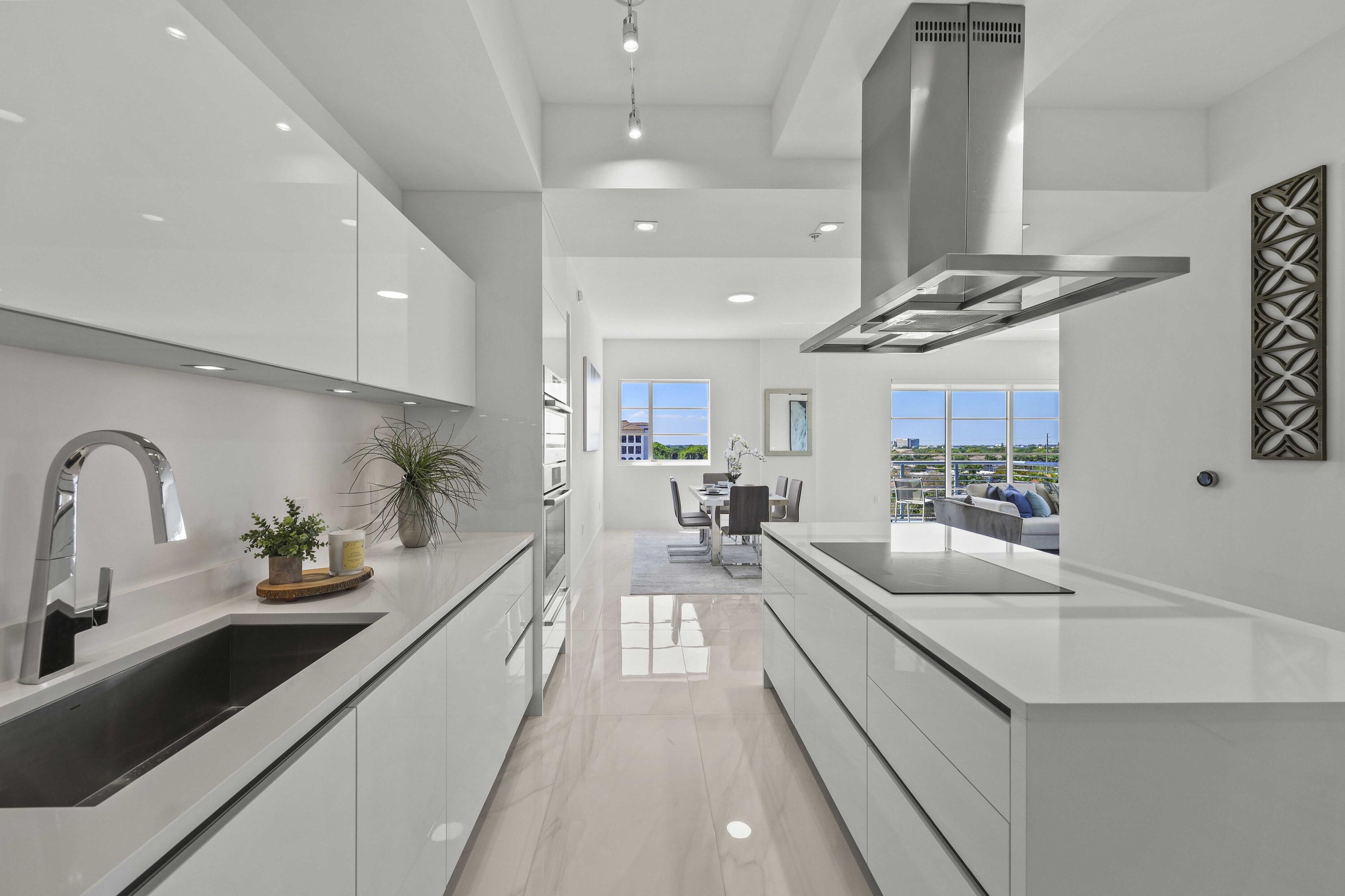 155 East Boca Raton Road, Unit 723 Boca Raton, FL 33432 - Photo 5 of 54 a large kitchen with kitchen island a large counter space a sink stainless steel appliances and cabinets