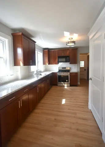 a large kitchen with stainless steel appliances granite countertop a sink counter space and cabinets