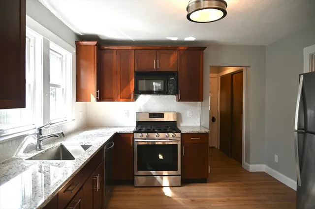 a kitchen with stainless steel appliances granite countertop a stove a sink and a refrigerator
