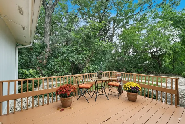 a view of a deck with two chair and wooden floor