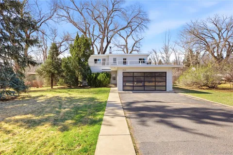 a front view of a house with a yard and trees