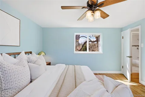 an empty room with wooden floor and ceiling fan