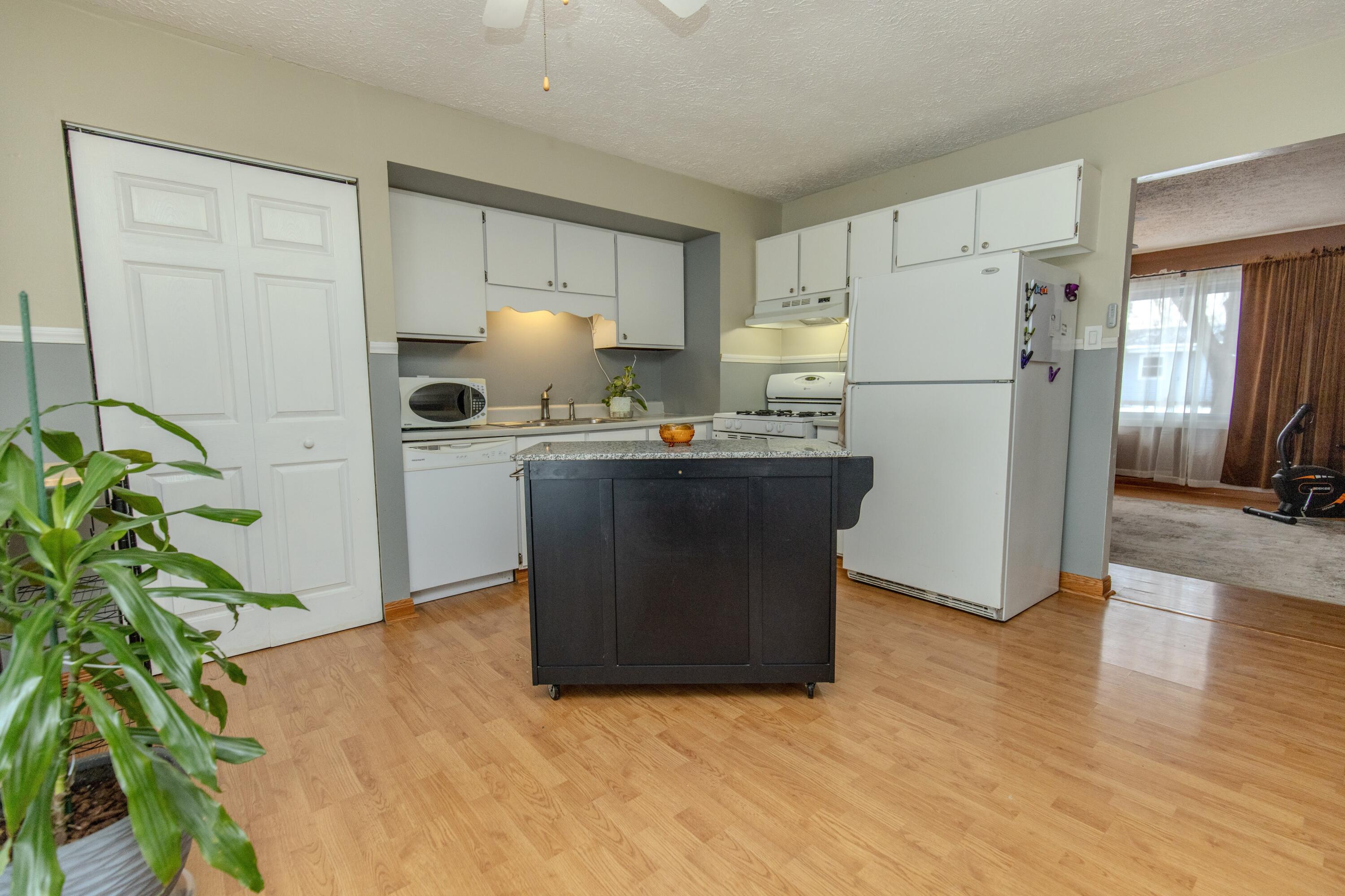 746-1 Acadia Road Valparaiso, IN 46385 - Photo 31 of 44 a kitchen with stainless steel appliances a refrigerator a sink a stove a refrigerator white cabinets and wooden floor