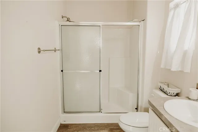 a white bed sitting in a bedroom next to a flat screen tv