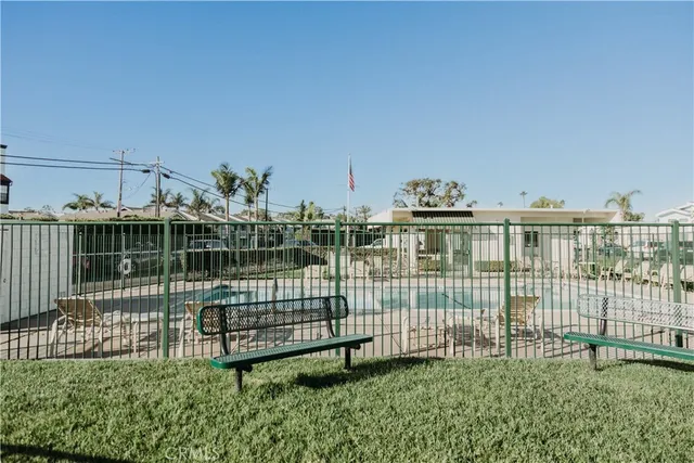 a kitchen with granite countertop a stove top oven a sink dishwasher and a refrigerator with wooden floor