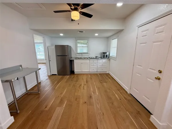 a large kitchen with a wooden floor and stainless steel appliances