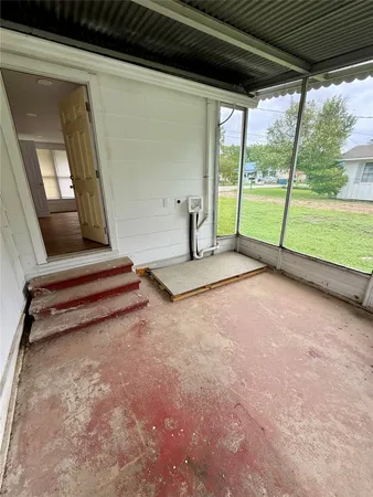 a view of an empty room with wooden floor and a floor to ceiling window