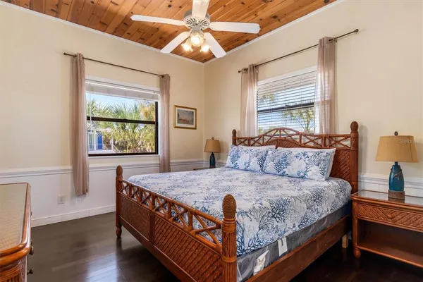 a spacious bedroom with a bed a mirror and a large window