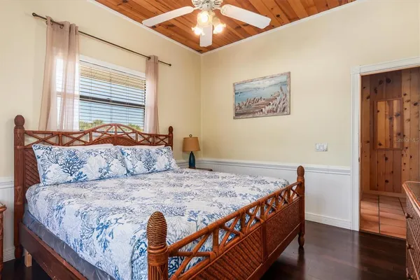 a spacious bedroom with a bed and wooden floor