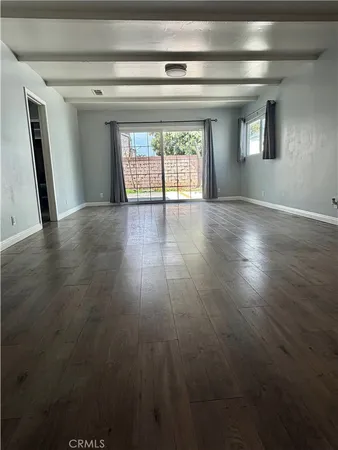 a view of empty room with wooden floor and fireplace