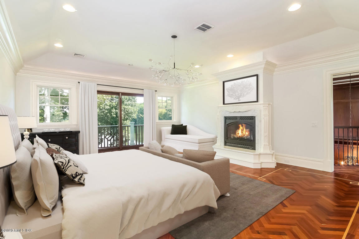 99 Valley Road, Unit E Cos Cob, CT 06807 - Photo 17 of 28 a spacious bedroom with a large bed and a fireplace