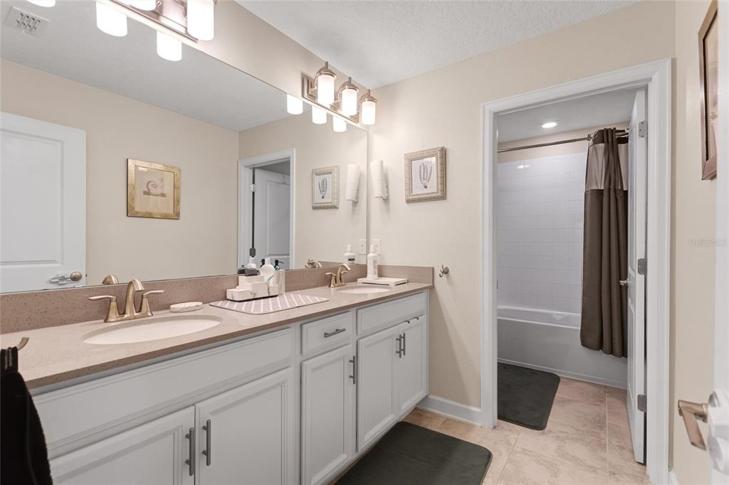 1089 Blackwolf Run Road Davenport, FL 33896 - Photo 27 of 82 a bathroom with a double vanity sink and a mirror