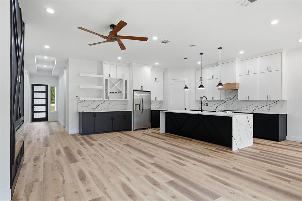 1111 Riverwood Road Dallas, TX 75217 - Photo 13 of 40 Open-concept living space featuring wood-finish flooring, a contemporary kitchen, and a dedicated beverage station