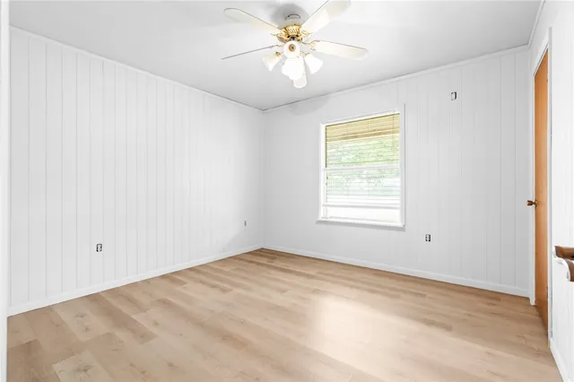 a view of a big room with windows and chandelier fan
