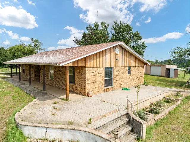 a view of house with yard and sitting area
