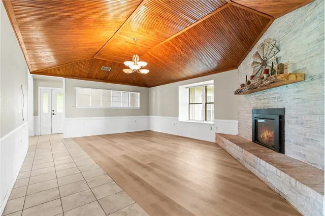 a view of an empty room with a window and fire place