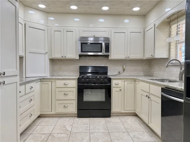 a kitchen with stainless steel appliances granite countertop a stove and a sink