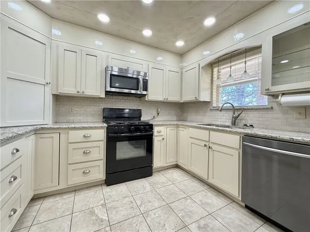 a kitchen with cabinets stainless steel appliances and window