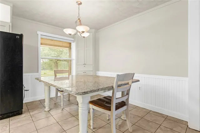 a dining room with chandelier and window