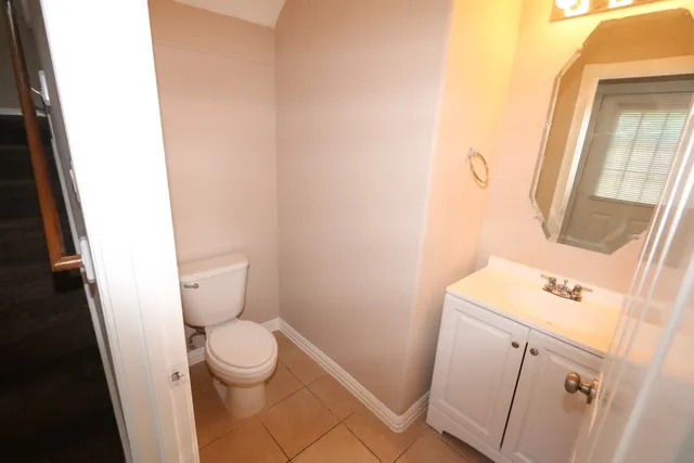 a white toilet sitting next to a sink and a vanity
