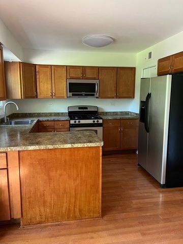 249 Shadow Bend Drive, Unit 249 Wheeling, IL 60090 - Photo 5 of 17 a kitchen with stainless steel appliances granite countertop a refrigerator a stove a sink and a microwave