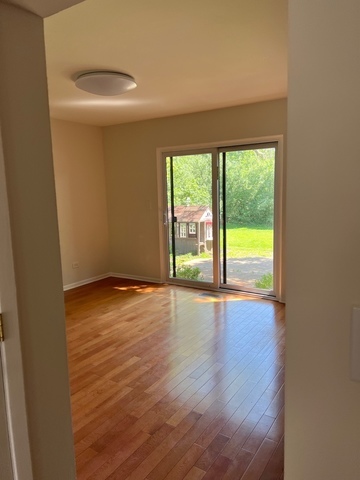 249 Shadow Bend Drive, Unit 249 Wheeling, IL 60090 - Photo 8 of 17 a view of an empty room with wooden floor and a window