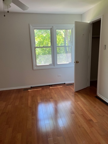 249 Shadow Bend Drive, Unit 249 Wheeling, IL 60090 - Photo 9 of 17 an empty room with wooden floor and windows