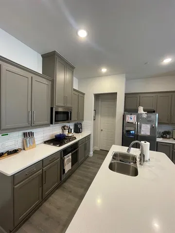 a kitchen with sink stove and refrigerator