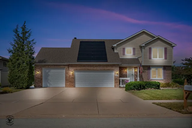 a front view of a house with yard and parking