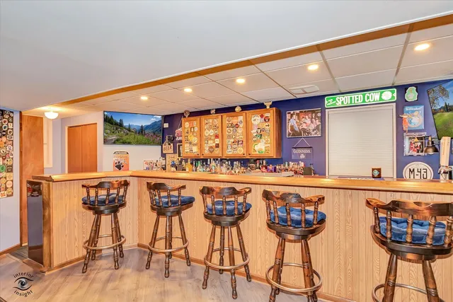 a kitchen with stainless steel appliances a dining table chairs stove and large window