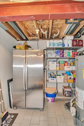 a utility room with lots of clutter and refrigerator