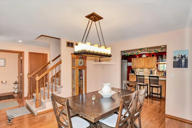 a dining room with furniture a chandelier and wooden floor