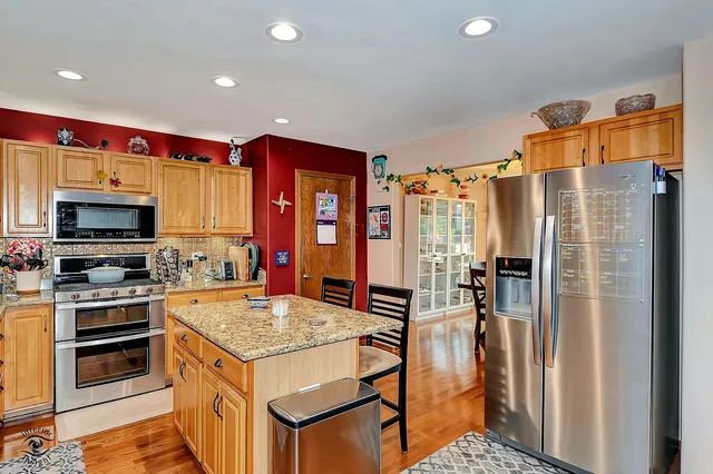 a kitchen with granite countertop a refrigerator and a stove top oven