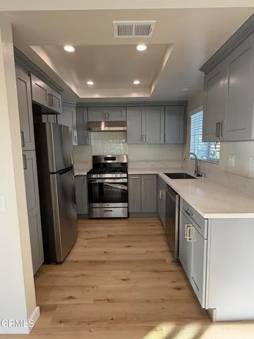 a kitchen with stainless steel appliances granite countertop a refrigerator a stove a sink and a microwave